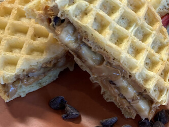 Closeup photo of peanut butter and jelly sandwich made with waffles rather than bread